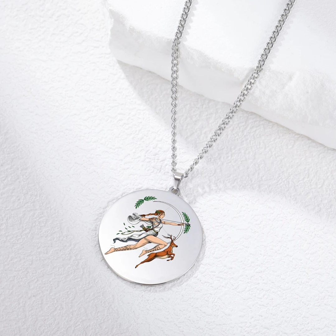 Silver necklace with a circular pendant featuring a design of Goddess Artemis and deer on a white fabric background.