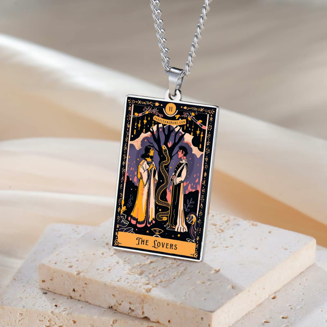 Tarot card pendant with 'The Lovers' design on a stone surface
