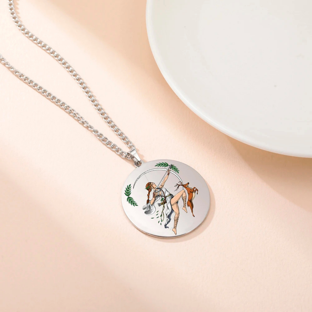 Necklace with a round pendant featuring a colorful illustration of Goddess Artemis on a beige background