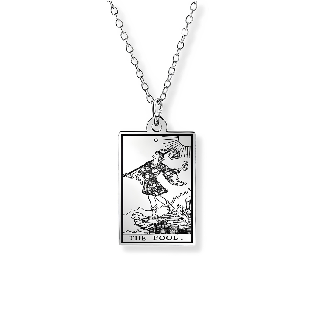 A silver-toned metal pendant necklace featuring the classic 'The Fool' tarot card illustration, suspended from a matching link chain against a plain white background.