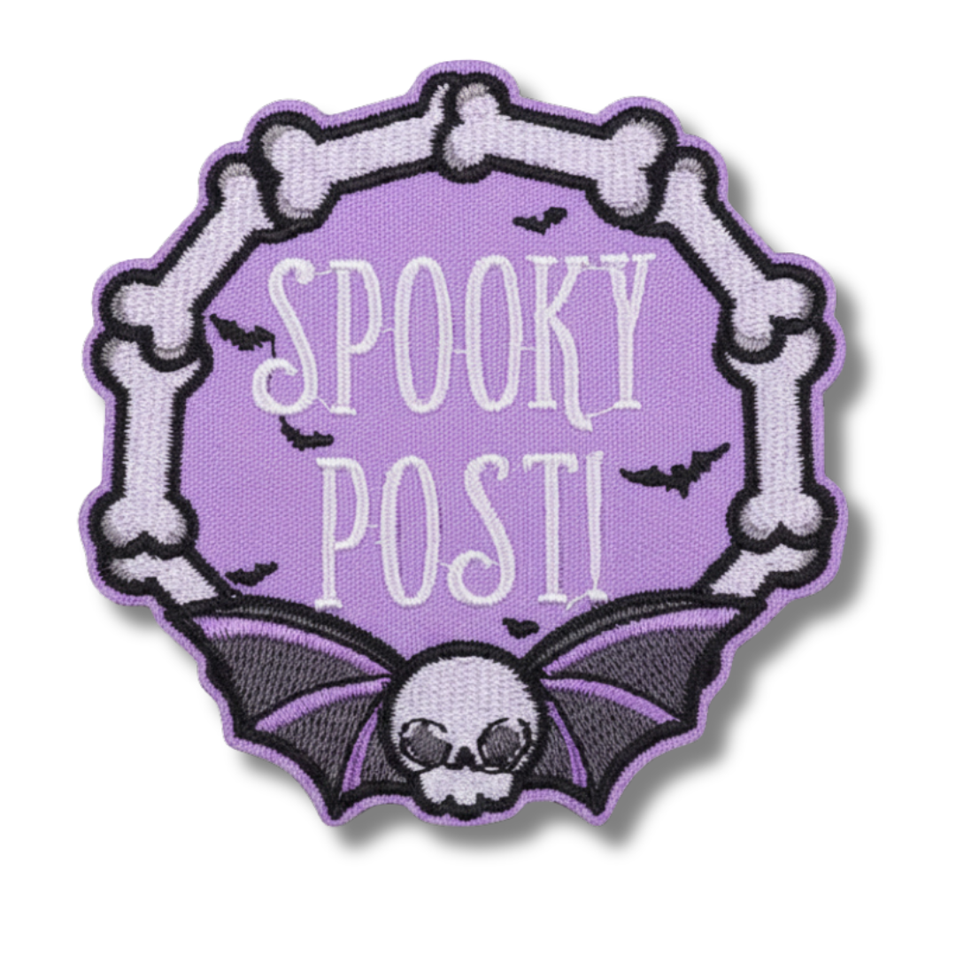 Embroidered patch with 'Spooky Post!' text, bat design, and skeleton bones on a purple background.