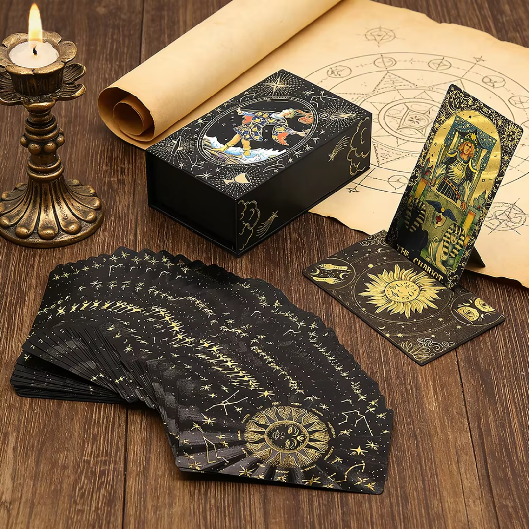 Set of tarot cards with a black box, candle, and rolled-up paper with astrological symbols on a wooden surface.