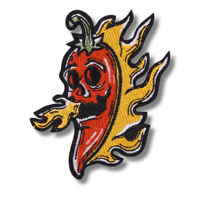 Embroidered patch of a red pepper with black eyes and yellow flames on a white background