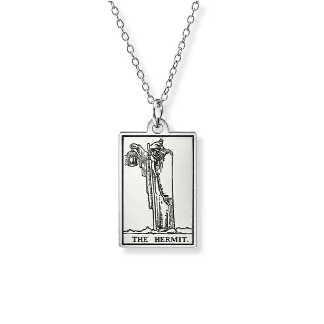 A silver-toned pendant necklace featuring a rectangular card design with the Hermit card illustration and the text 'THE HERMIT' at the bottom, shown on a white background.