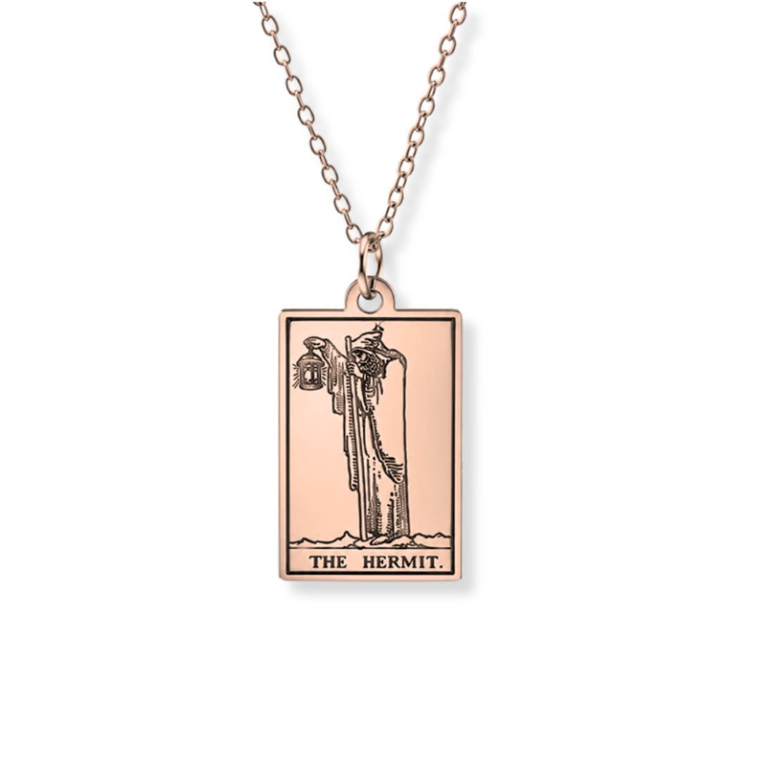 A rose gold rectangular pendant necklace featuring the 'The Hermit' tarot card design, suspended from a matching rose gold chain against a plain white background.