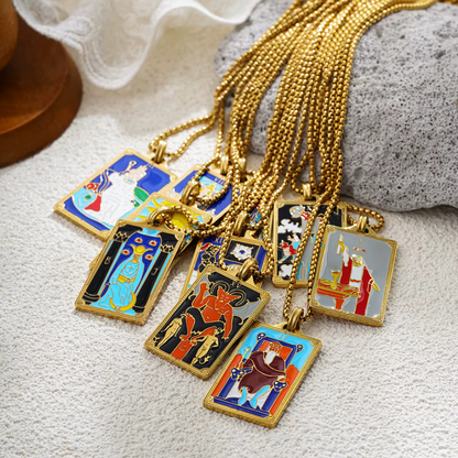 Collection of tarot card-themed pendants on gold chains against a rock background