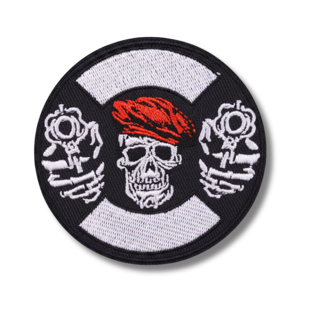 Circular patch with a skull wearing a red bandana, crossed bones, and a white center on a black border.