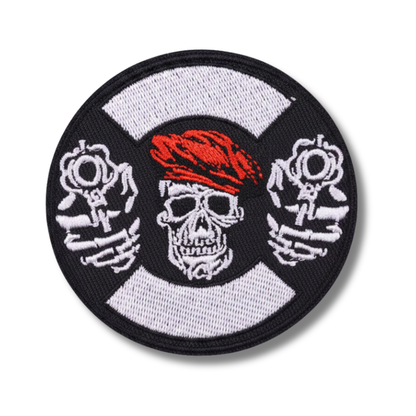 Circular patch with a skull wearing a red bandana, crossed bones, and a white center on a black border.