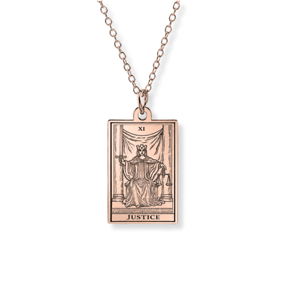 A rose gold pendant necklace featuring the Justice tarot card (XI), suspended from a matching rose gold chain against a clean white background.