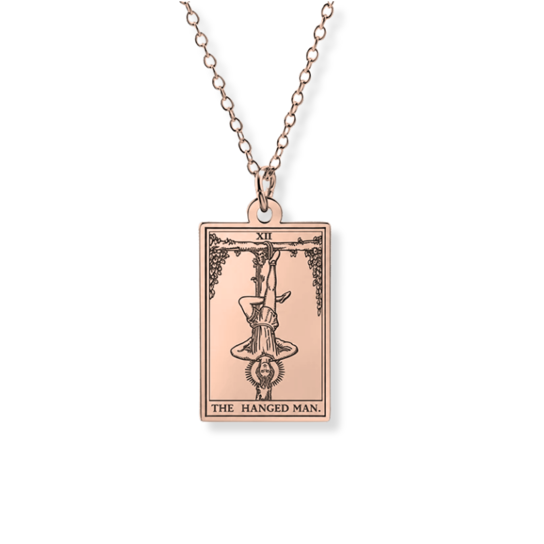 A rose gold tarot card pendant necklace featuring 'The Hanged Man' card design, suspended from a matching rose gold chain against a plain white background.