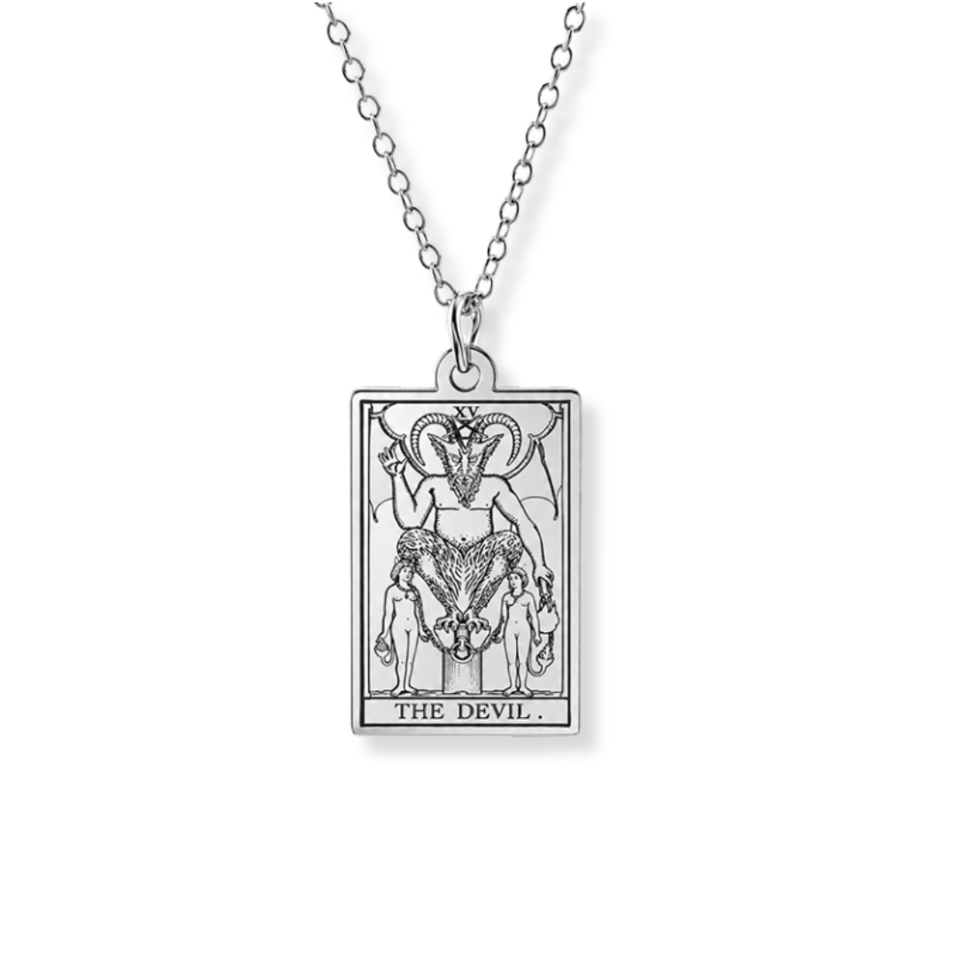 A silver tarot card pendant necklace featuring 'The Devil' card design, suspended from a delicate silver link chain against a plain white background.