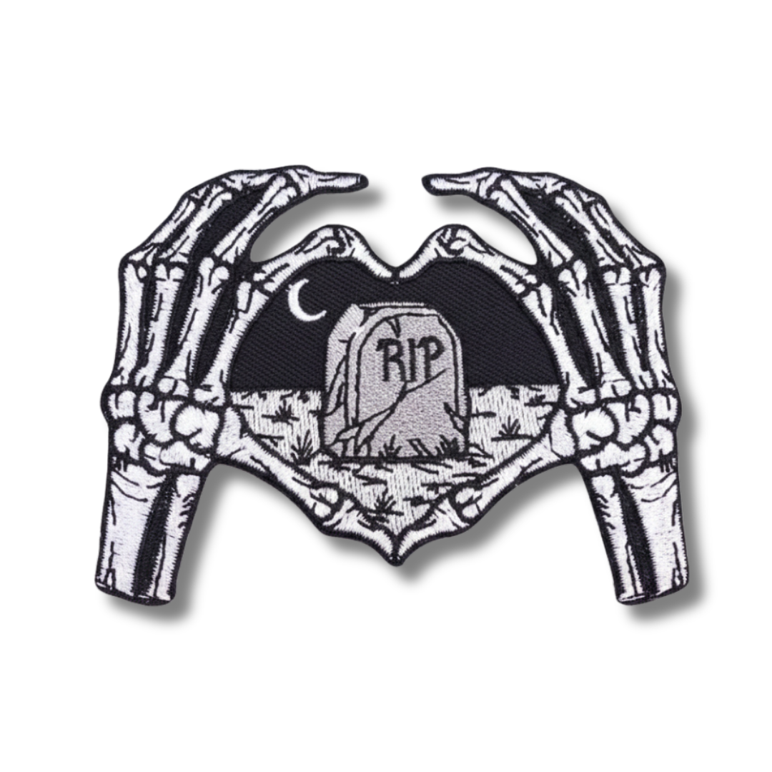 Skeletal hands holding a heart with 'RIP' text on a white background