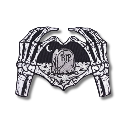 Skeletal hands holding a heart with 'RIP' text on a white background