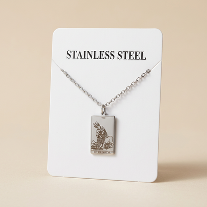 A stainless steel tarot card pendant necklace on a matching chain, displayed on a white backing card labeled 'STAINLESS STEEL'.