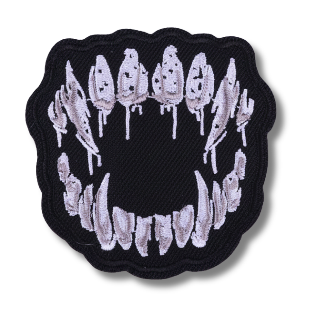Embroidered patch of a mouth with teeth on a black background
