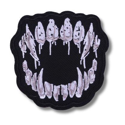Embroidered patch of a mouth with teeth on a black background