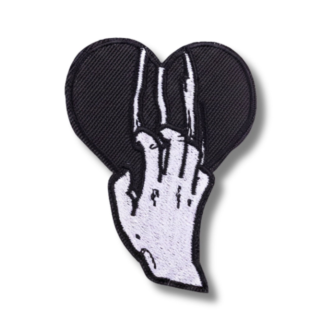 Embroidered patch of a hand holding a heart on a white background