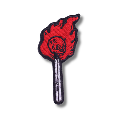 Flame-shaped patch with a skull design on a white background