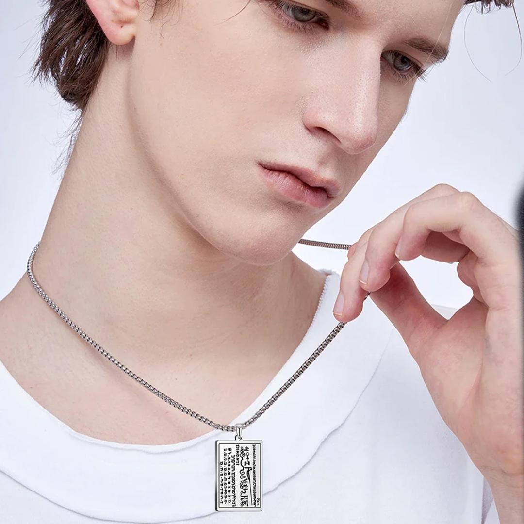 Person wearing a silver 6th & 7th Books of Moses necklace with a rectangular pendant, against a plain background