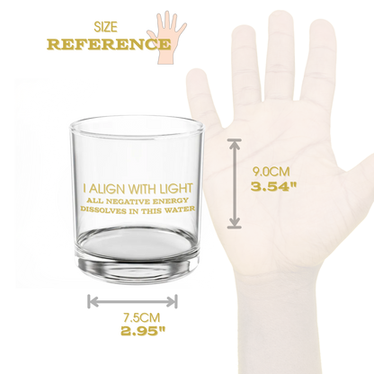 Clear glass mug with text and measurement chart next to a hand