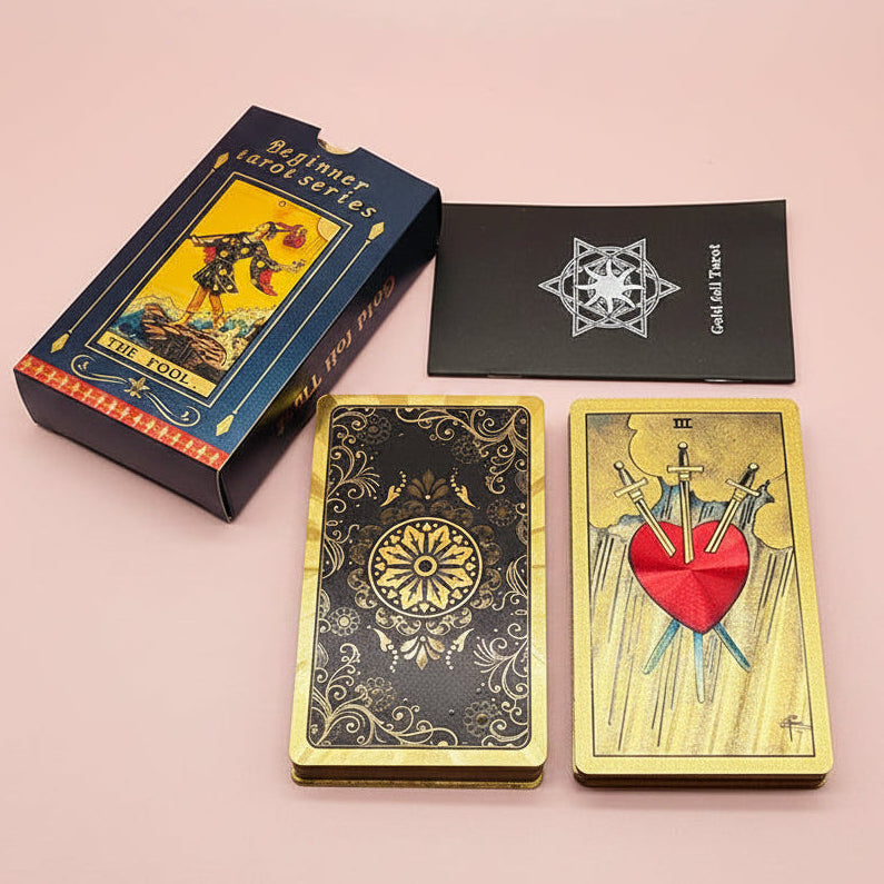 Gold tarot cards with intricate designs and a box labeled 'Beginner tarot series' on a light gray background.