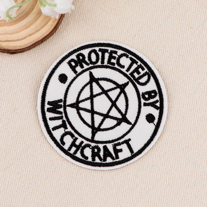 Round patch with 'Protected by Witchcraft' text and pentagram symbol on a beige background